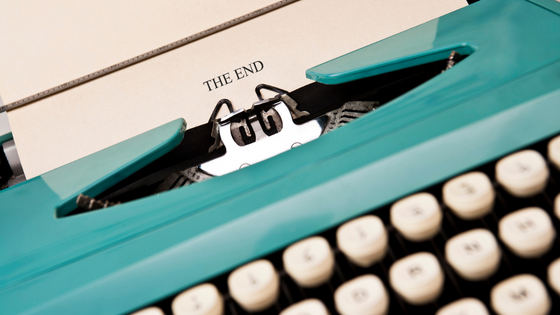 Turquoise typewriter with the words The End